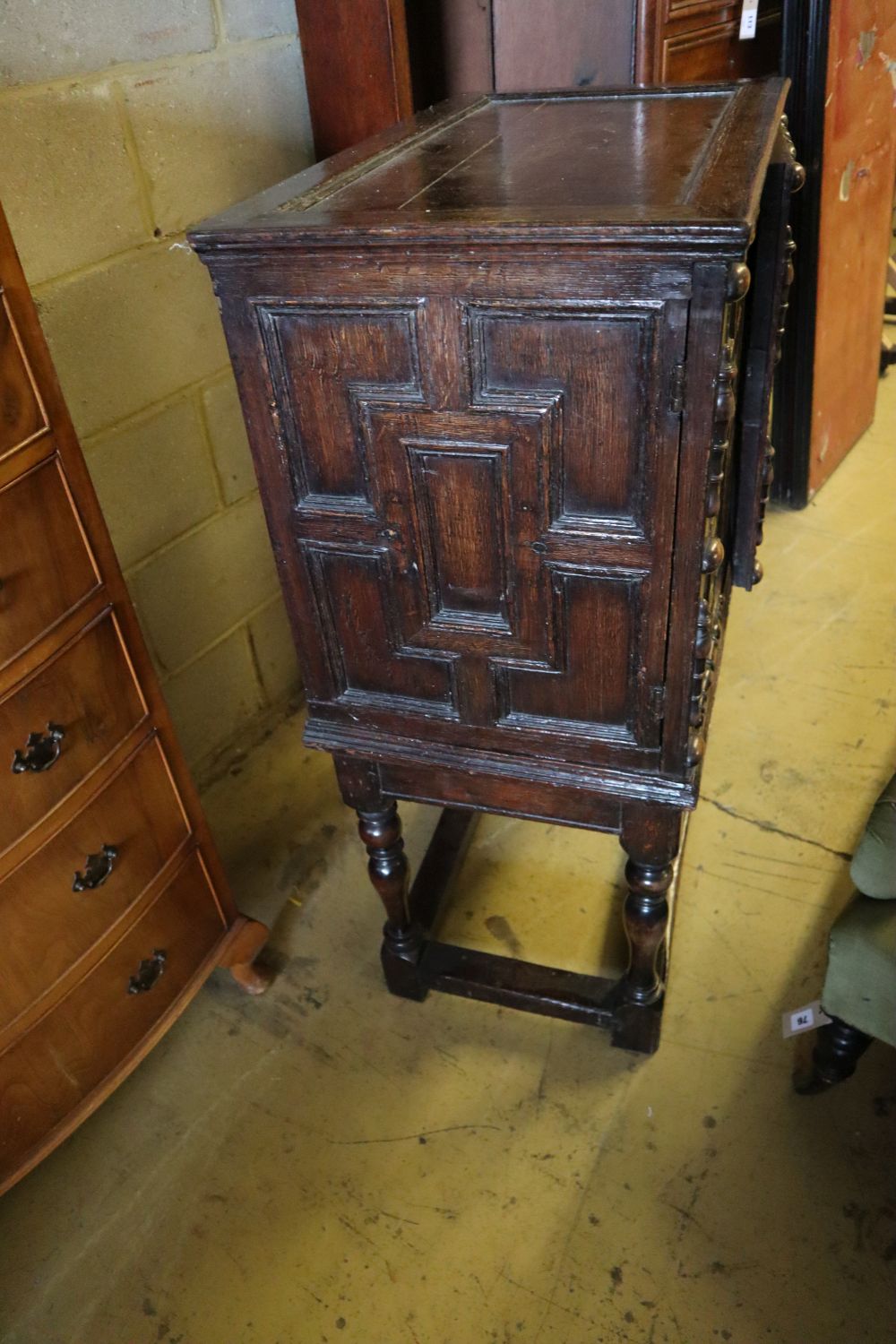 A 17th century and later oak cabinet of drawers enclosed by a pair of panelled doors, with retailers plaque, width 74cm depth 44cm hei